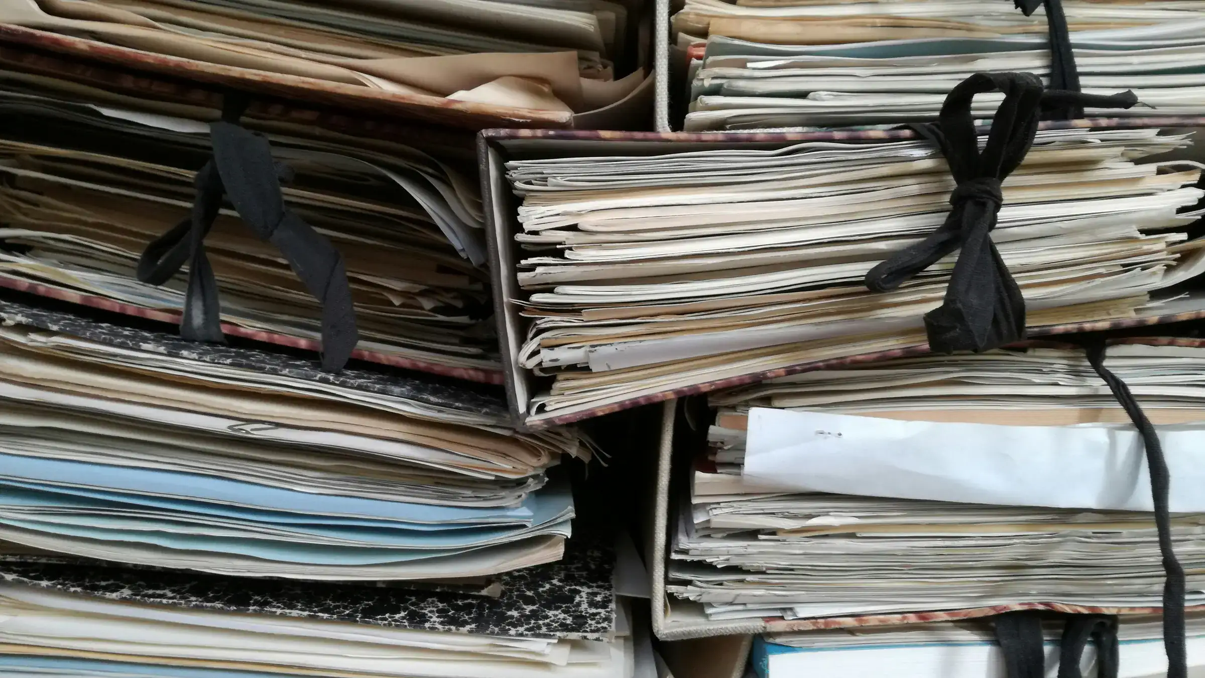 Expedientes de papel amarrados en un archivo